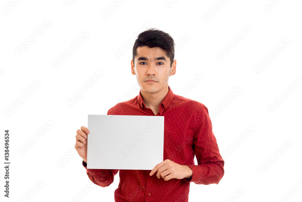 serious young guy in a red shirt holding a white leaf serious young guy in a red shirt holding a white leaf