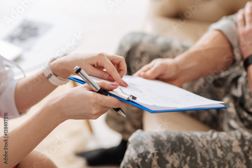 Nice military man taking a sheet of paper photo