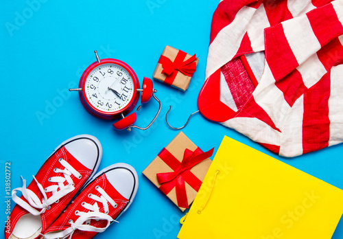 big red gumshoes, cool shopping bag, striped jacket on hanger, alarm clock and beautiful gifts on the wonderful blue background