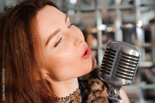 Rock star. Sexy Girl singing in retro microphone