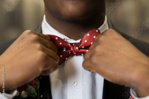 Adjusting red bowtie for prom