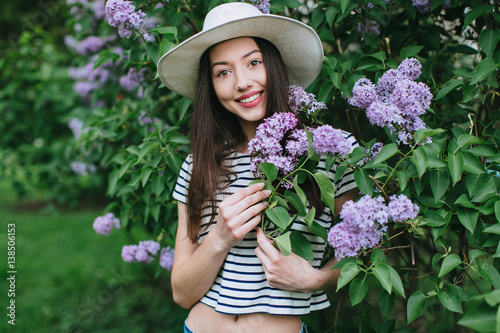 Portrait of stylish hipster girl among blossoming lilac. © anatoliycherkas
