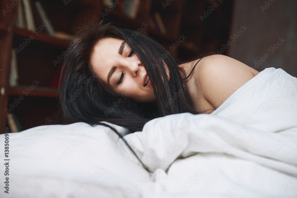 sensual woman with dark hair lying on a bed sensual woman with dark hair lying on a bed