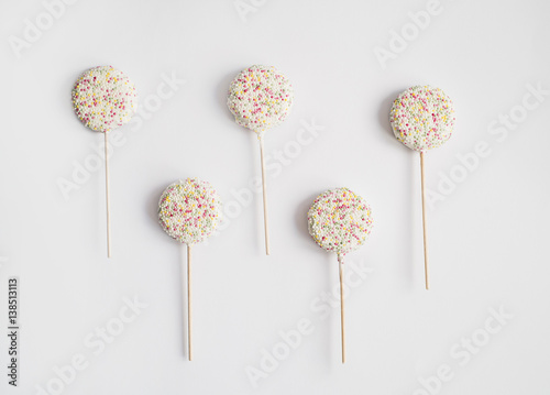 Candy lollipops with sprinkles on white background