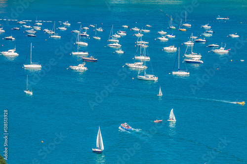 Boats and speedboats parked offshore