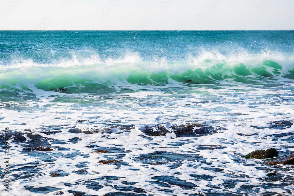 Fototapeta premium Perfect turquoise wave breaking at the beach