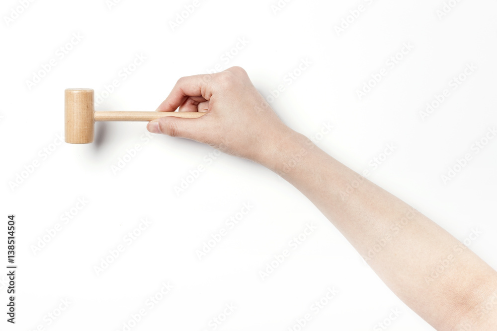 woman hand hold a small wood hammer isolated white. woman hand hold a small wood hammer isolated white.