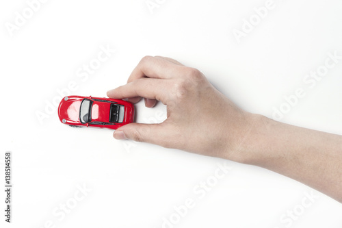 woman hand hold a red mini sports car isolated white