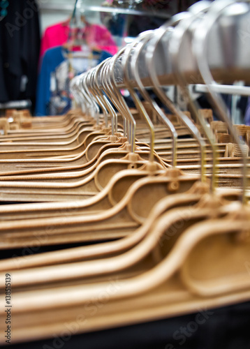 Yellow plastic hangers in a clothes shop, close-up. © kurbanov_vener