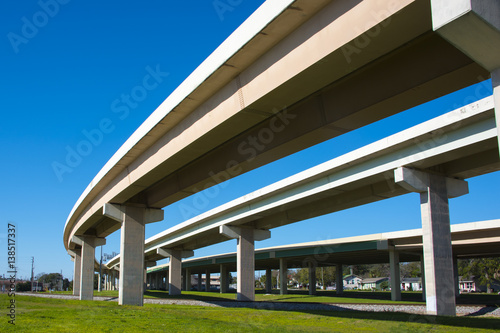 Obraz na plátne Highway overpass crossing neighborhood with a blue sky background