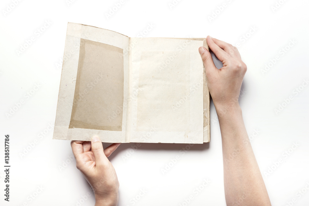Obraz premium woman hand hold a vintage book isolated white.