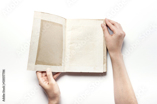 woman hand hold a vintage book isolated white.