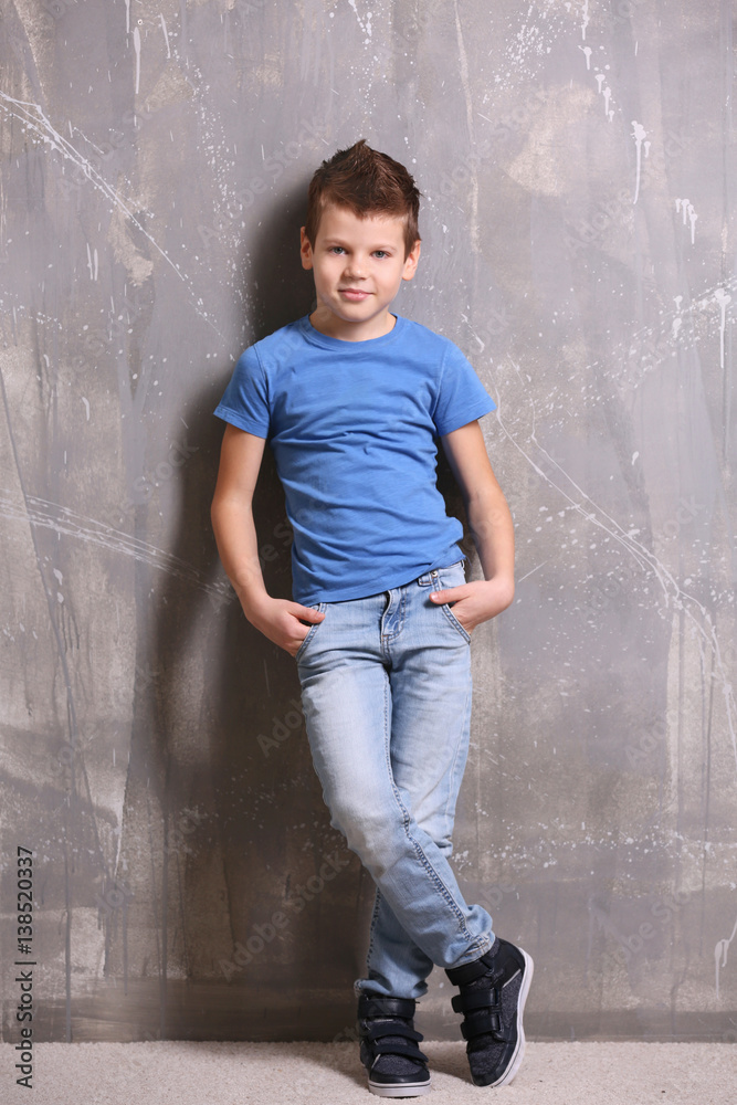 Cute little boy on grey textured background