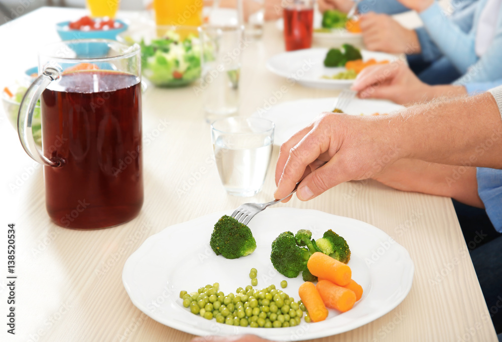 Man eating vegetables during lunch at home, closeup Man eating vegetables during lunch at home, closeup