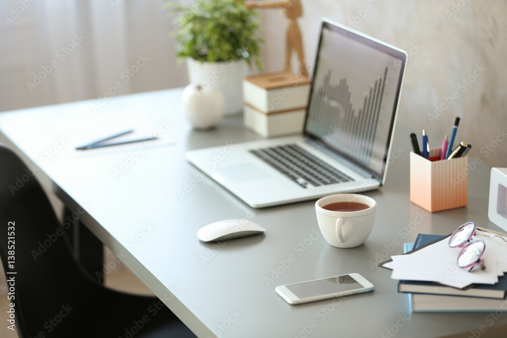 Fototapeta premium Workplace with laptop on table in modern room