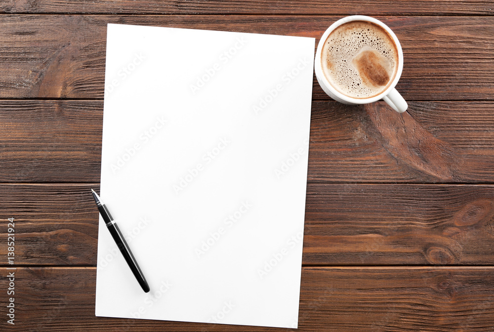 Cup of coffee and paper with pen on wooden table Cup of coffee and paper with pen on wooden table