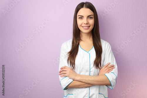 Young specialist in beauty salon against color wall