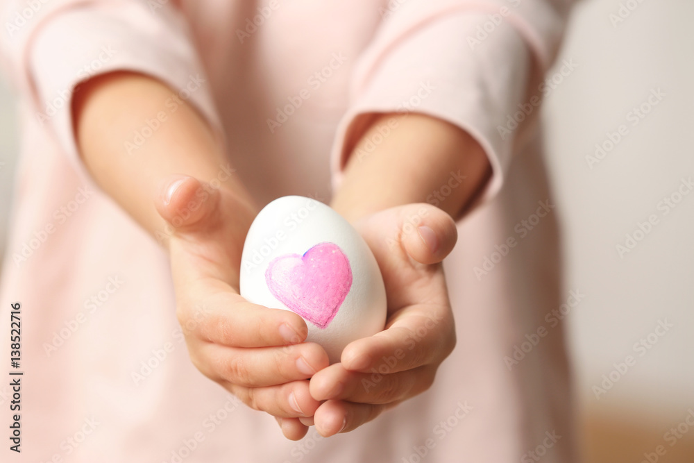 Hands of cute little child holding Easter egg, closeup Hands of cute little child holding Easter egg, closeup