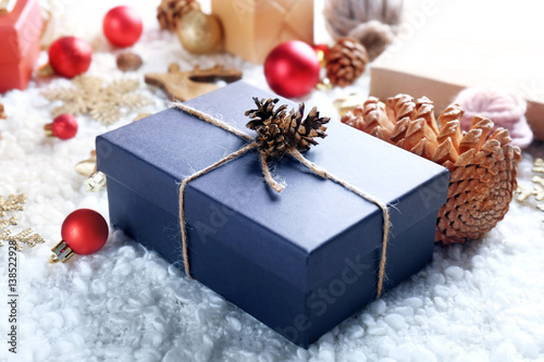 Gift box and Christmas decorations on wooden background