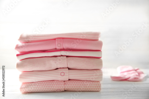 Pile of baby clothes and socks on wooden table