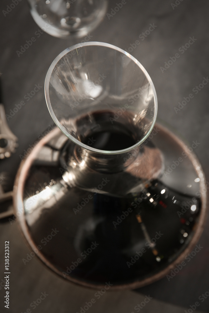 Glass carafe of red wine on gray background