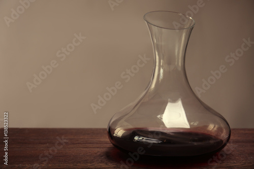 Glass carafe of red wine on wooden table