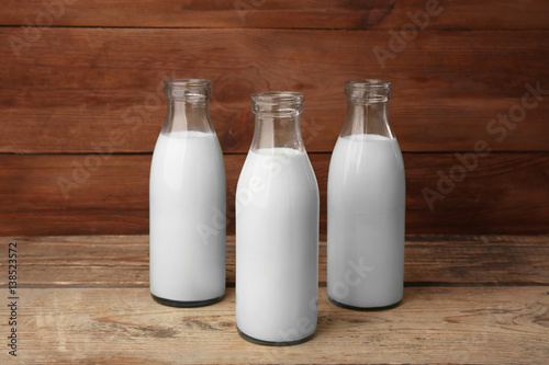 Three bottles of milk on wooden background