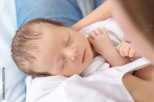 Mother with cute sleeping baby at home, closeup