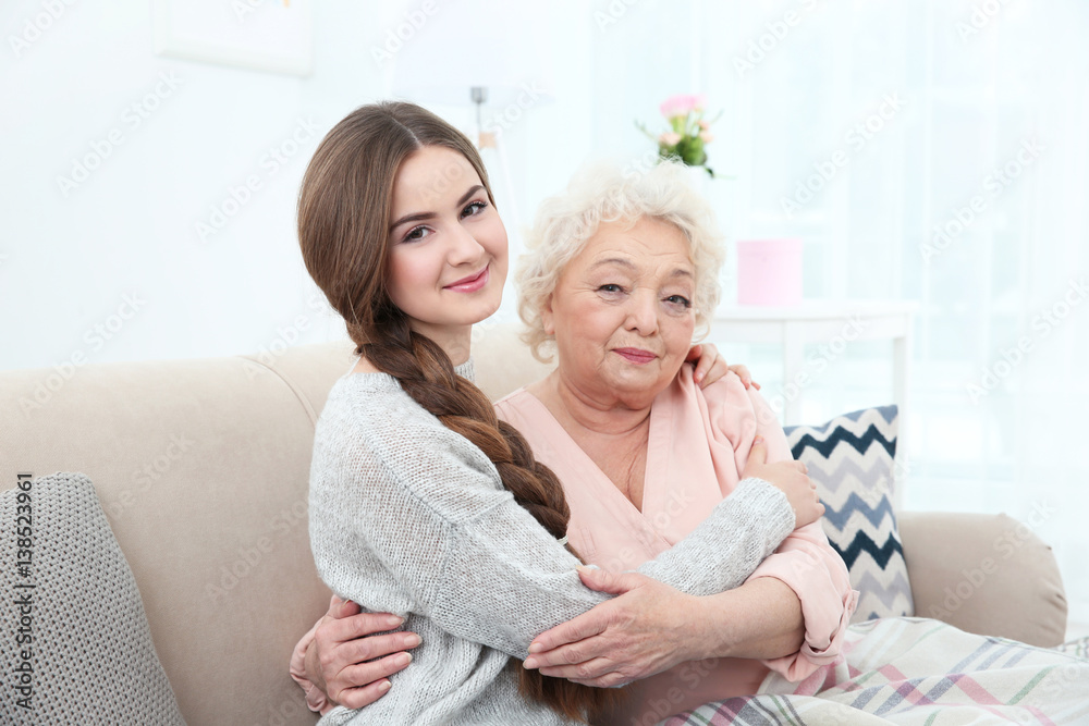 Beautiful girl with grandmother on couch at home Beautiful girl with grandmother on couch at home