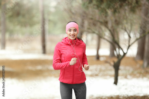 Young woman jogging in winter park © Africa Studio