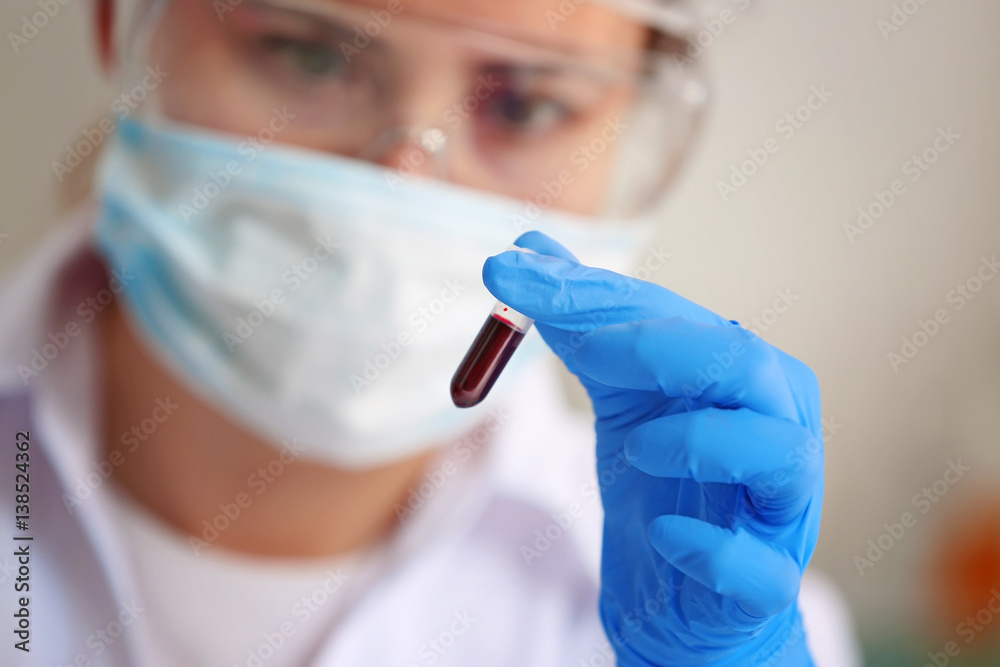 Woman holding glass tube with blood in laboratory, closeup Woman holding glass tube with blood in laboratory, closeup