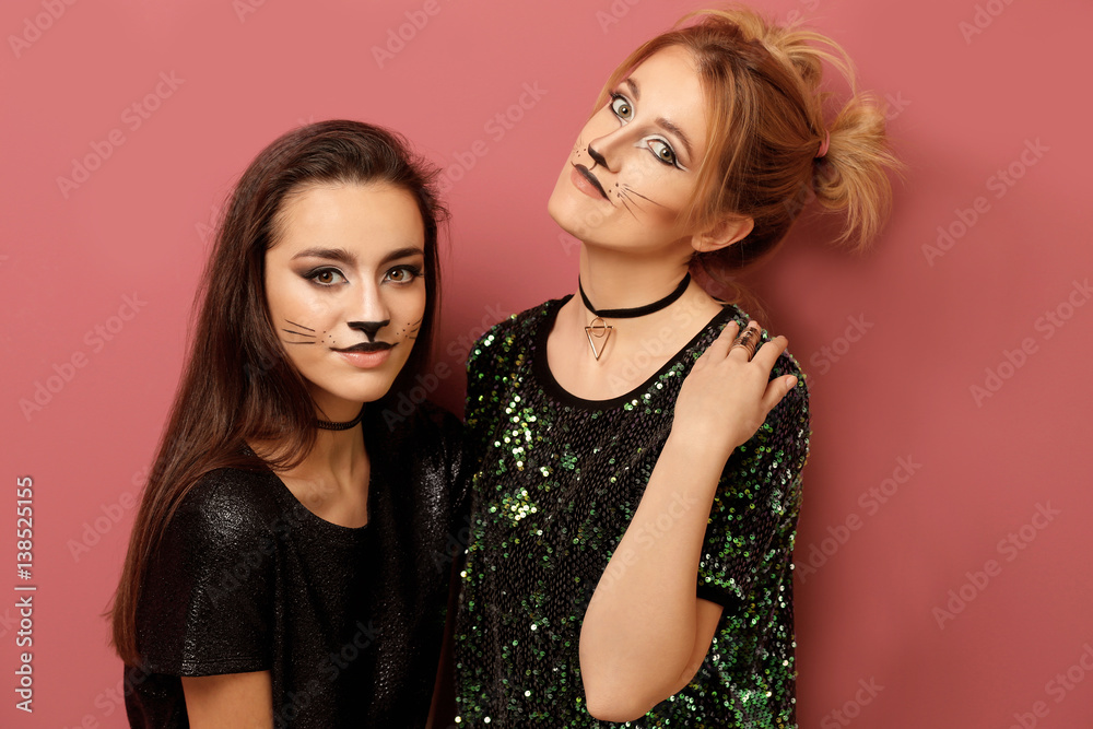 Beautiful young women with cat makeup on color background Beautiful young women with cat makeup on color background