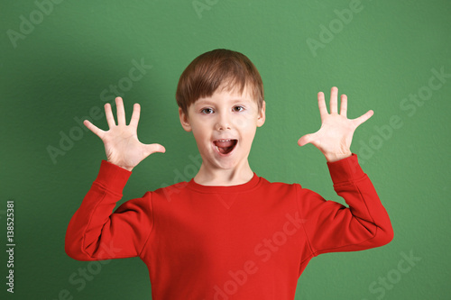 Cute little boy on color ba...