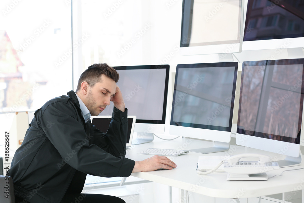 Fototapeta premium Handsome security guard sleeping in surveillance room