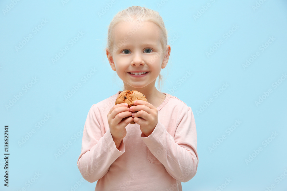 Cute little girl holding cookie on light background Cute little girl holding cookie on light background