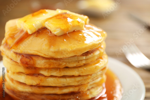 Delicious pancakes with butter and maple syrup, closeup