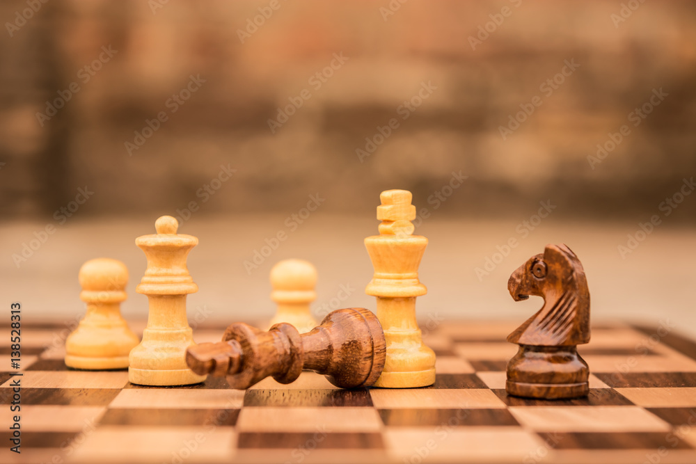 Wooden chess pieces against bricks Wooden chess pieces against bricks