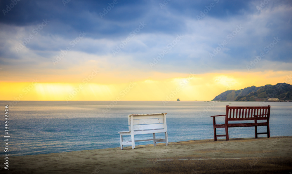 夕暮れのビーチとベンチ