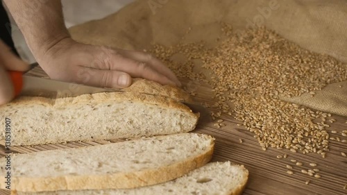 Cut slice of bread on the wooden table, in slow motion, close up