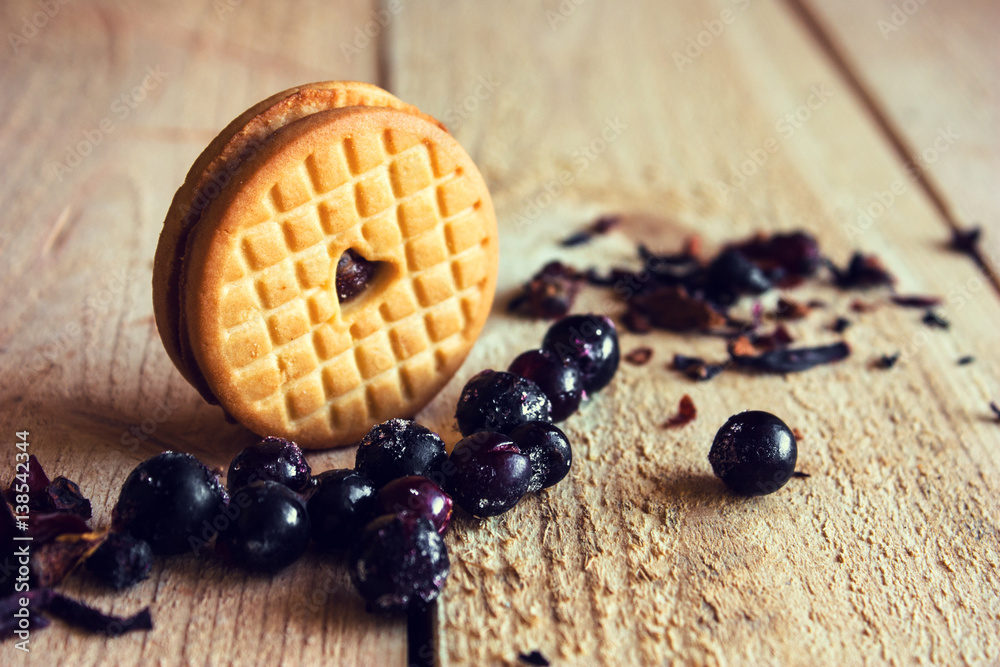 Cookie with a heart on a background of black currant berries Cookie with a heart on a background of black currant berries