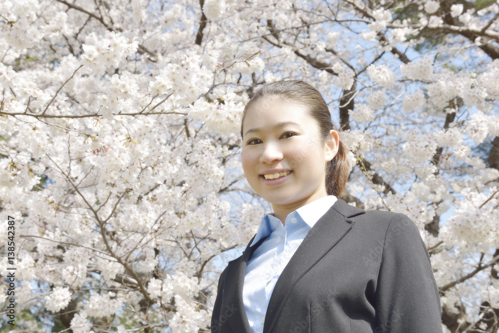 満開の桜の木の下のビジネスウーマン