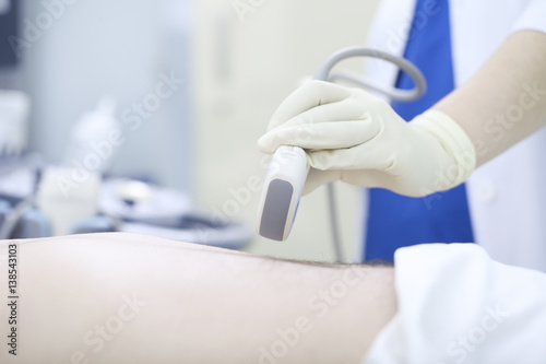 Doctor conducting ultrasound examination of abdomen to a patient