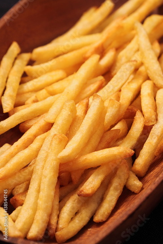 Pile of chips or French fries in a wooden bowl