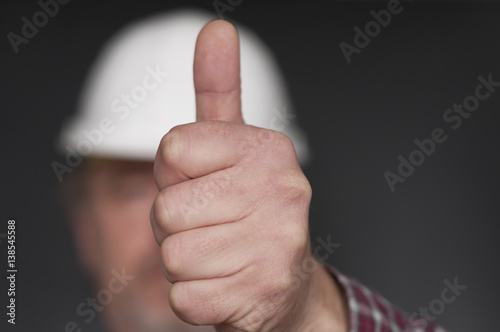 Bauarbeiter zeigt Hand mit Daumen nach oben / Positive Emotion, Bauarbeiter zeigt Hand mit Daumen hoch, geringe Tiefenschaerfe. photo