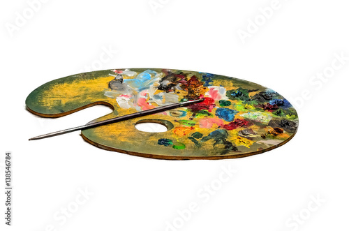 Colourful artists oil paint palette and brushes on white background © suman
