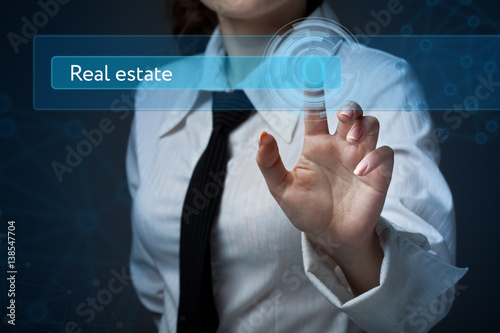 Business, technology, internet and networking concept. Business woman presses a button on the virtual screen: Real estate