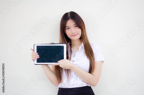 Portrait of thai adult student university uniform beautiful girl using her tablet.