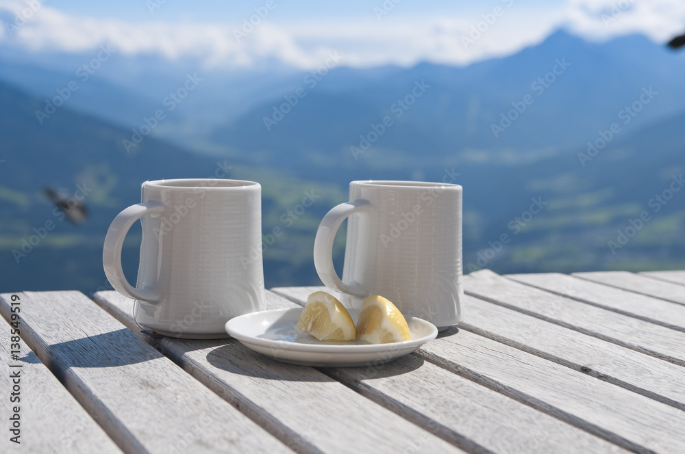Two cups of tea with lemon on a table in a cafe in the mountains
