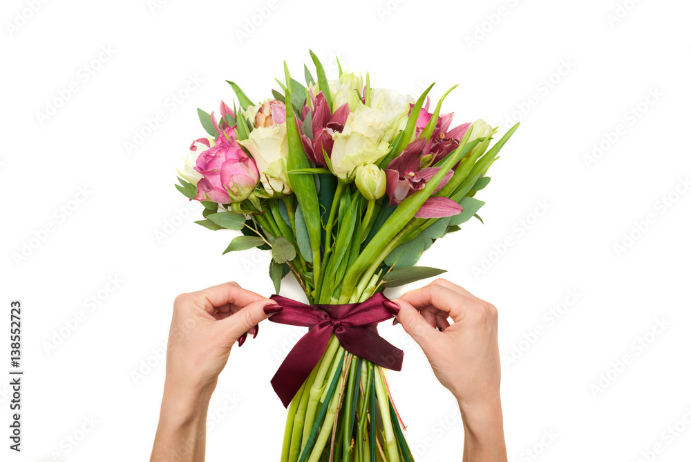 Hands tied the bouquet with a ribbon of spring flowers