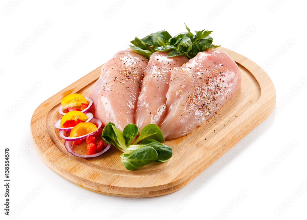 Raw chicken breasts on cutting board 